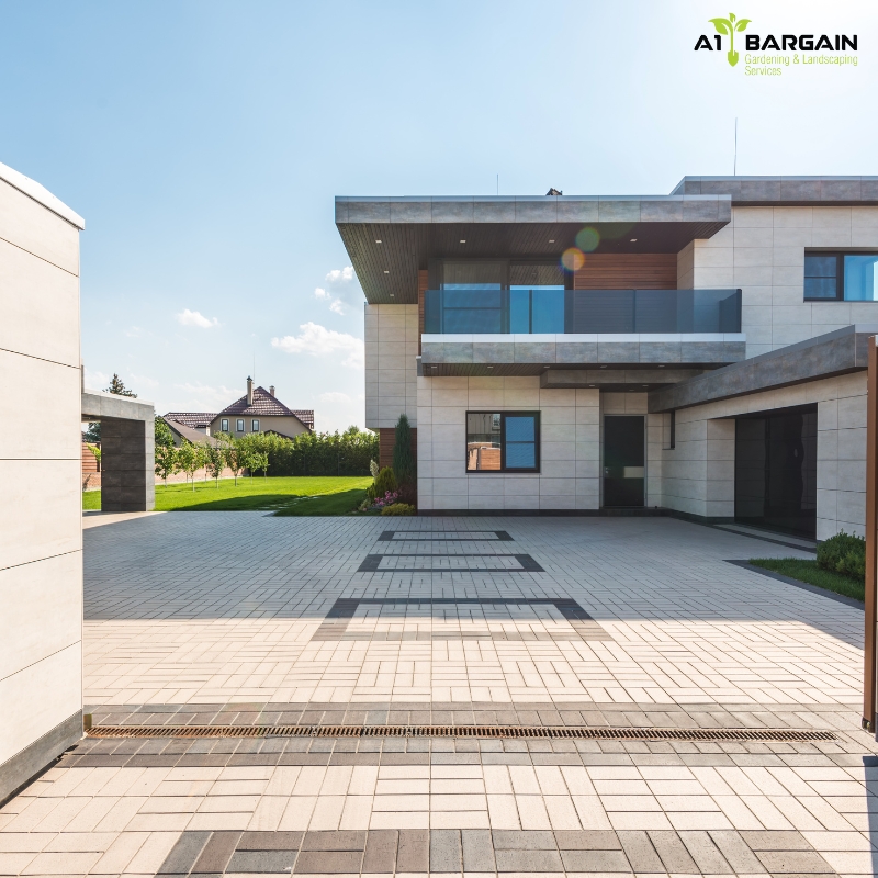 Modern home with a spacious, clean brick driveway showcasing premium driveway paving in Sydney with lush green lawn and garden.