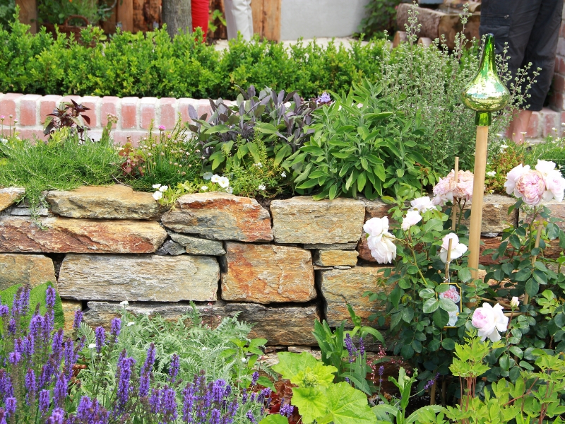 Retaining wall with flowers maintained under a structured garden maintenance plan.