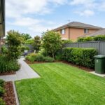 Well-maintained Sydney garden with mowed lawn, trimmed hedges and tidy garden beds