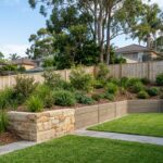 Retaining wall in a Sydney backyard with sandstone and concrete sleepers